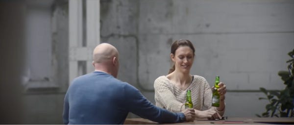 A man and a woman enjoy a beer together.